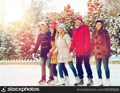 people, winter, friendship, sport and leisure concept - happy friends ice skating and holding hands on rink outdoors. happy friends ice skating on rink outdoors
