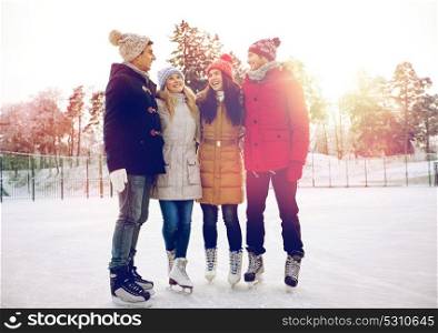 people, winter, friendship, sport and leisure concept - happy friends ice skating and hugging on rink outdoors. happy friends ice skating on rink outdoors