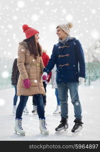 people, winter, friendship, sport and leisure concept - happy friends ice skating on rink outdoors