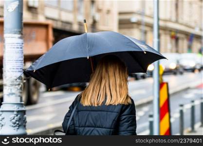 People with umbrella on the street on a rainy day in Bucharest, Romania, 2021