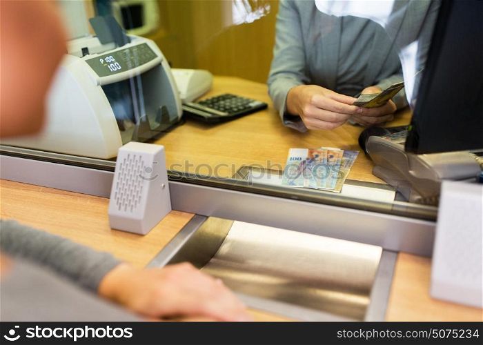 people, withdrawal, money, saving and finance concept - clerk counting swiss francs cash at bank office or currency exchanger. clerk counting cash money at bank office