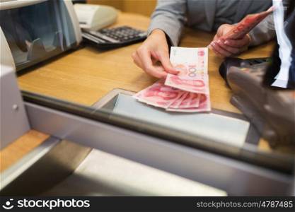 people, withdrawal, saving and finance concept - clerk counting cash money at bank office or currency exchanger