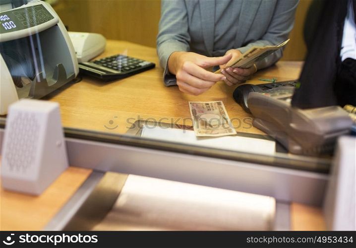 people, withdrawal, saving and finance concept - clerk counting cash money at bank office or currency exchanger. clerk counting cash money at bank office