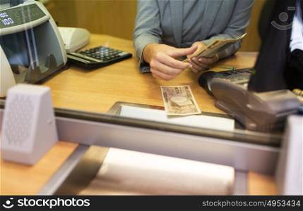 people, withdrawal, saving and finance concept - clerk counting cash money at bank office or currency exchanger. clerk counting cash money at bank office