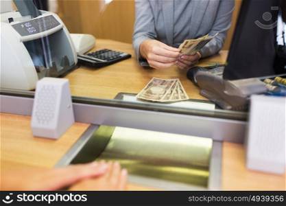 people, withdrawal, saving and finance concept - clerk counting cash money for customer at bank office or currency exchanger. clerk counting cash money at bank office