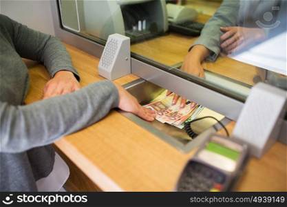 people, withdrawal, saving and finance concept - clerk giving cash money to customer at bank office or currency exchanger. clerk giving cash money to customer at bank office