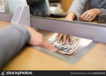 people, withdrawal, saving and finance concept - clerk giving cash money to customer at bank office or currency exchanger. clerk giving cash money to customer at bank office