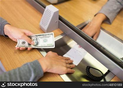 people, withdrawal, saving and finance concept - customer with cash money taking receipt from clerk at bank office or currency exchanger