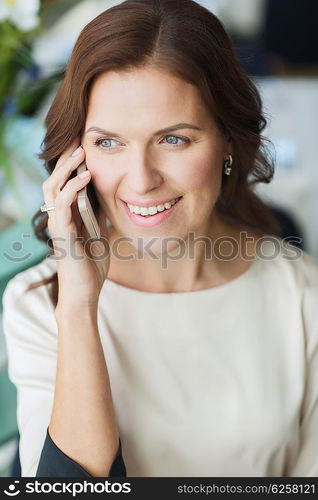 people, women, business and lifestyle concept - happy woman calling on smart phone at restaurant