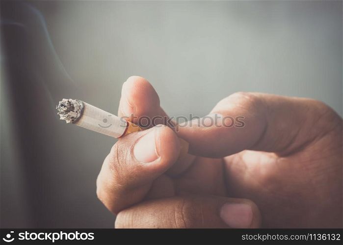 people young man smoking Cigarettes tobacco in hand with a soft-focus. concept quit Cigarettes are dangerous to health.