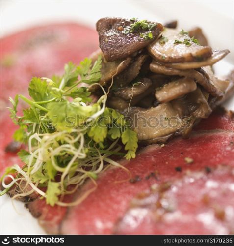 Pepper charred beef carpaccio with mushrooms.