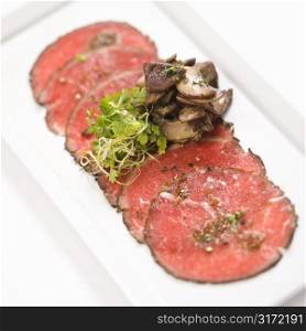 Pepper charred beef carpaccio with mushrooms.