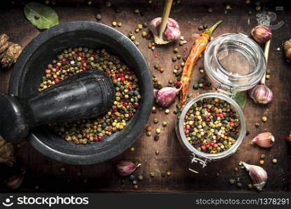 Pepper in a mortar on a wooden tray. On a rustic background.. Pepper in a mortar on a wooden tray.