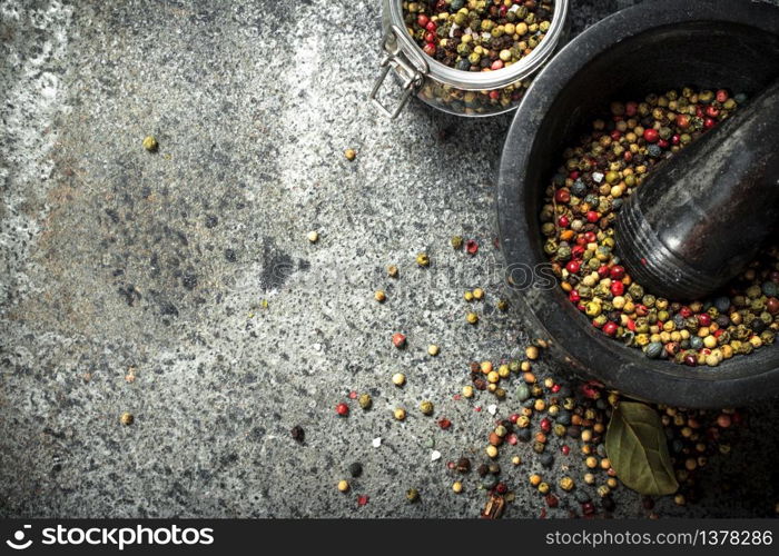 Pepper in a mortar with a pestle. On a rustic background.. Pepper in a mortar with a pestle.