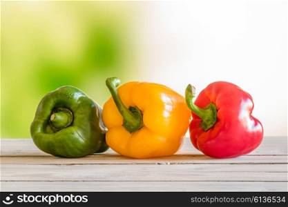 Pepper on a row on a wooden table in a garden