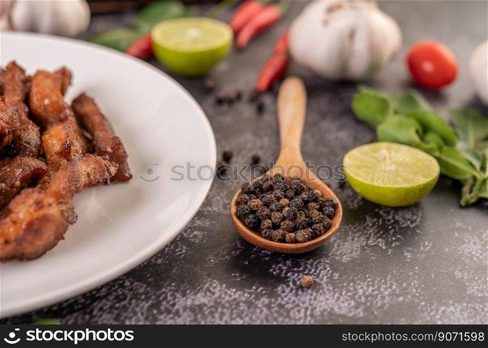 Pepper seeds in a wooden spoon on the black cement floor. Selective focus.