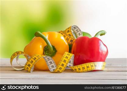 Pepper with measure tape on a wooden table in a garden
