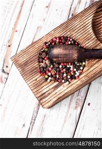 peppercorn in rustic mortar. Red, white and black pepper in a wooden mortar