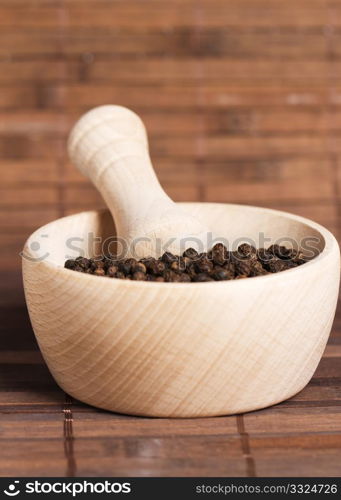 peppercorns in a wooden mortar. peppercorns in a wooden mortar on wooden background