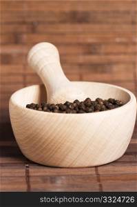 peppercorns in a wooden mortar. peppercorns in a wooden mortar on wooden background