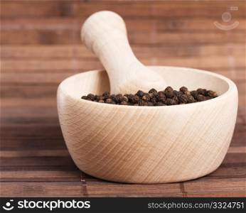 peppercorns in a wooden mortar. peppercorns in a wooden mortar on wooden background