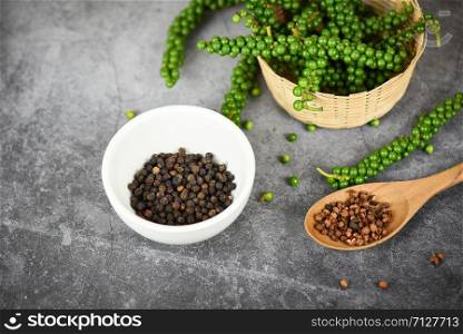 peppercorns on basket and dark background / fresh green peppercorn and black pepper seed on white cup for ingredients cuisine thai food herbs and spices