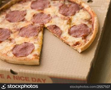 Pepperoni Pizza in a Take Away Box with a Slice Taken