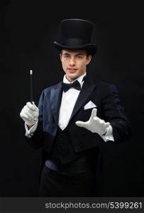 performance, circus, show concept - magician in top hat with magic wand showing trick