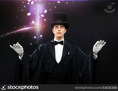 performance, circus, show concept - magician in top hat with magic wand showing trick