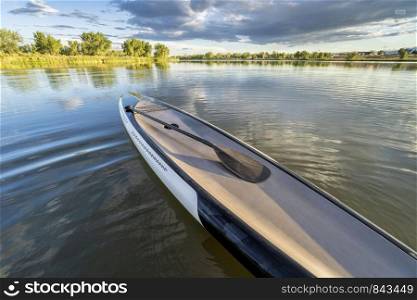 performance stand up paddleboard with a paddle on a calm mountain lake in Colorado
