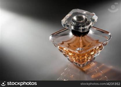 Perfume in a stylish glass jar on abstract background