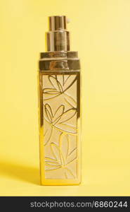 Perfume in bottle on a yellow background