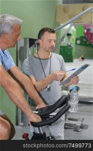 peronsal trainer with a senior man in the gym