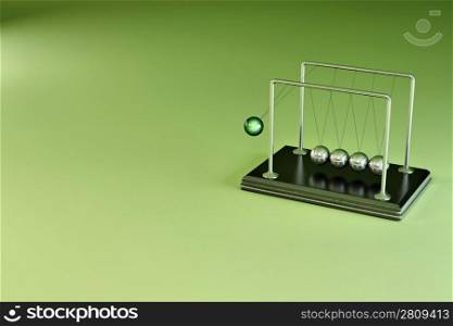 Perpetual motion. Pendulum on green background. 3d