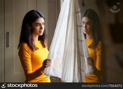 Persian woman at home while looking through the window. Persian woman while looking through the window
