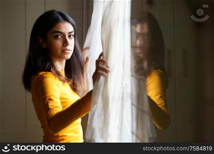 Persian woman at home while looking through the window. Persian woman while looking through the window