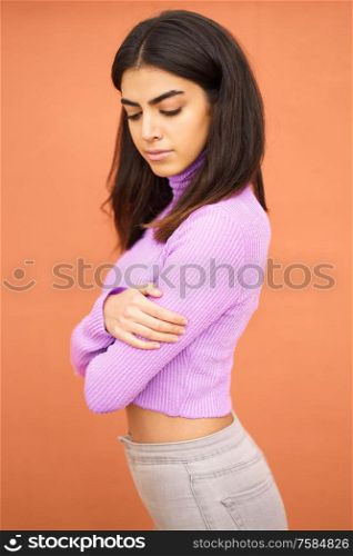 Persian woman standing outdoors on red wall background. Persian woman standing outdoors on red wall