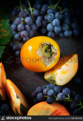 Persimmon and grapes still life.Autumn season food photo