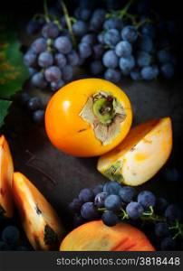 Persimmon and grapes still life.Autumn season food photo