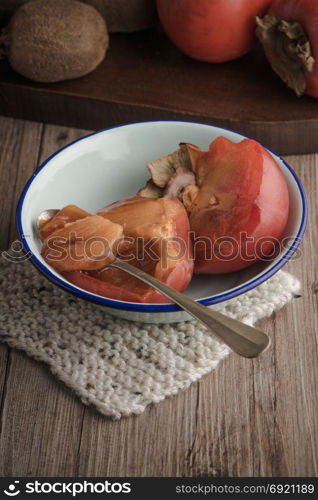 Persimmon fruit on rustic table in vintage style.