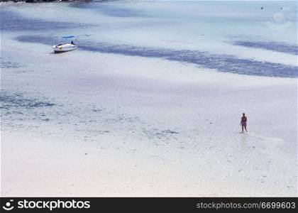 Person and Boat in Shallow Tropical Water