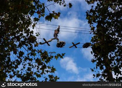Person crossing the Go Ape tree top course in Battersea Park, London