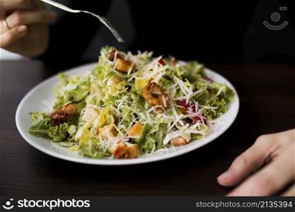 person eating tasty caesar salad with croutons restaurant