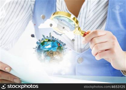 Person exploring Earth planet. Close view of businessperson exploring Earth planet with magnifying glass. Elements of this image are furnished by NASA