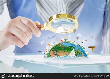 Person exploring Earth planet. Close view of businessperson exploring Earth planet with magnifying glass. Elements of this image are furnished by NASA