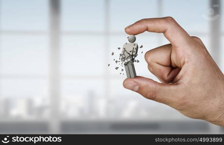 Person figure between fingers. Close view of male hand taking with fingers male figure