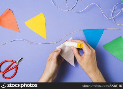 person hand sticking bunting paper with glue stick