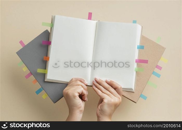 person holding books with colorful reminders stickers