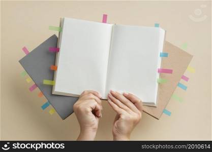 person holding books with colorful reminders stickers