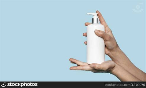 person holding bottle liquid soap with copy space